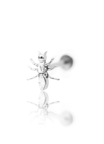 Srebrny kolczyk w kształcie mrówki typu labret na jasnym tle